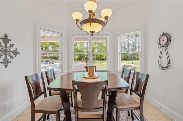 dining room featuring crown molding, baseboards, light tile patterned floors, and a healthy amount of sunlight