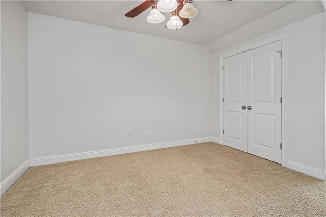 interior space with baseboards, light colored carpet, and ceiling fan