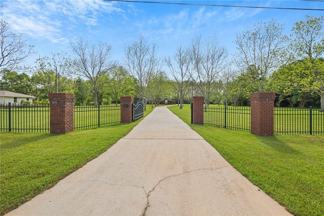 surrounding community featuring a fenced front yard, a lawn, and concrete driveway
