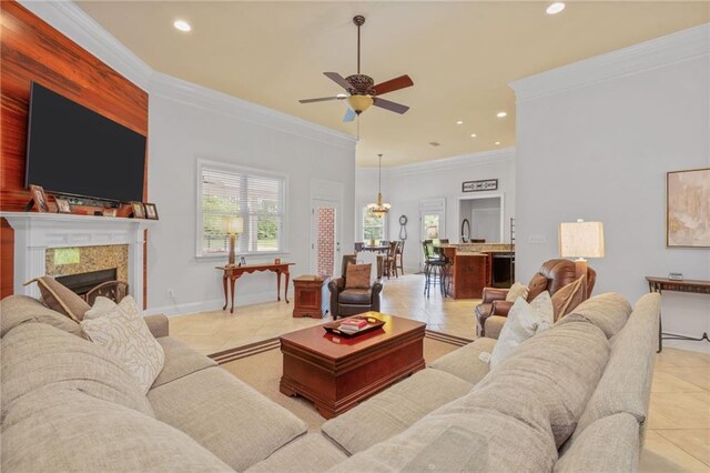 living area featuring ceiling fan with notable chandelier, light tile patterned flooring, recessed lighting, and crown molding