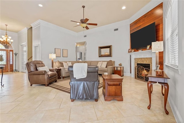 living room with ceiling fan with notable chandelier, a tile fireplace, light tile patterned floors, and crown molding