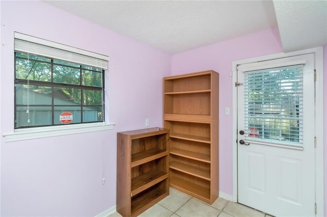 1000 Choctaw Bluff Rd, Mobile, AL 36695 - doorway featuring a textured ceiling, light tile patterned floors, and baseboards