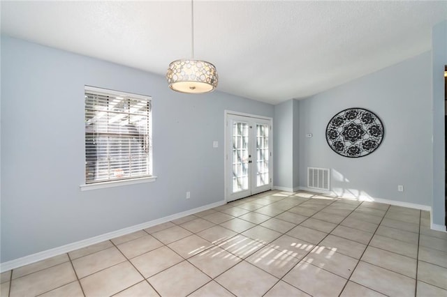 empty room with french doors and light tile patterned floors