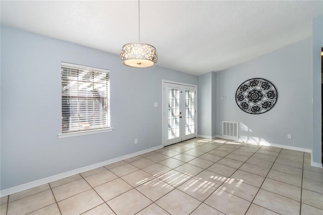 1000 Choctaw Bluff Rd, Mobile, AL 36695 - unfurnished room featuring french doors, light tile patterned floors, a textured ceiling, and baseboards