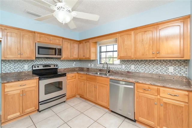 kitchen with ceiling fan, appliances with stainless steel finishes, backsplash, a textured ceiling, and sink