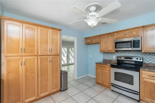 kitchen with stainless steel appliances, light tile patterned floors, backsplash, and ceiling fan