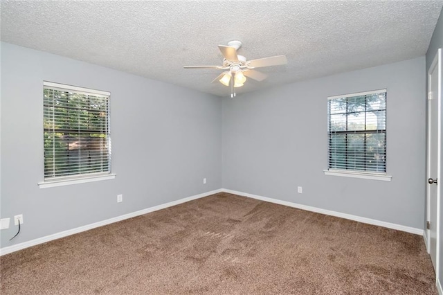 empty room with a textured ceiling, carpet floors, and ceiling fan