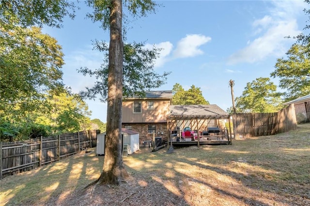 rear view of house with a wooden deck and a shed