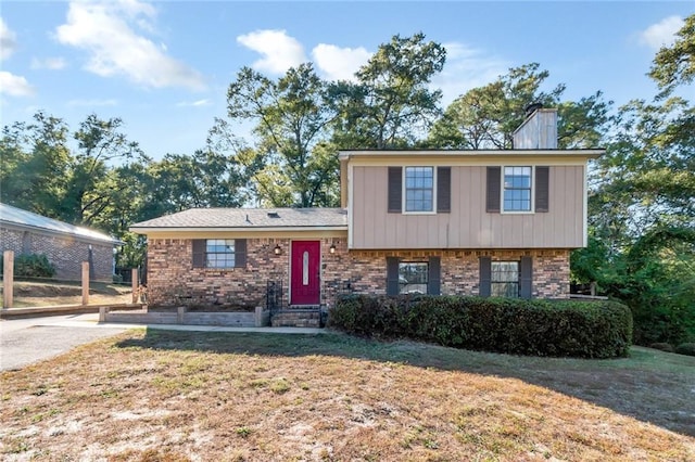 1000 Choctaw Bluff Rd, Mobile, AL 36695 - tri-level home with brick siding, a chimney, and a front lawn