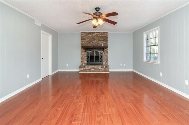 unfurnished living room featuring ornamental molding, hardwood / wood-style floors, a fireplace, and a textured ceiling