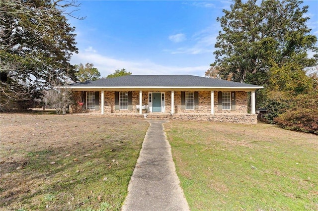 ranch-style house featuring a front lawn and covered porch