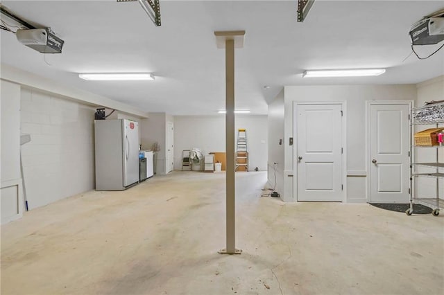 311 Magnolia Ave Unit 54, Satsuma, AL 36572 - garage featuring freestanding refrigerator and a garage door opener