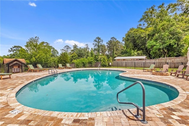 311 Magnolia Ave Unit 54, Satsuma, AL 36572 - community pool with an outdoor fire pit, a patio, a fenced backyard, and view of wooded area