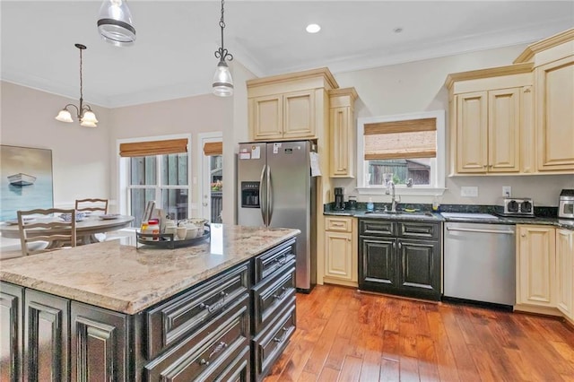 311 Magnolia Ave Unit 54, Satsuma, AL 36572 - kitchen with appliances with stainless steel finishes, cream cabinetry, a sink, pendant lighting, and ornamental molding