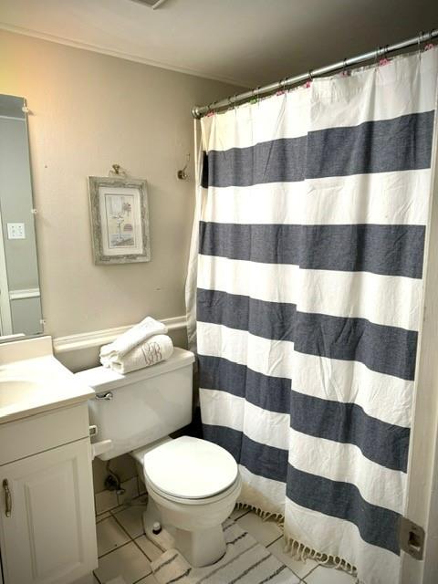 bathroom featuring tile patterned flooring, vanity, walk in shower, and toilet