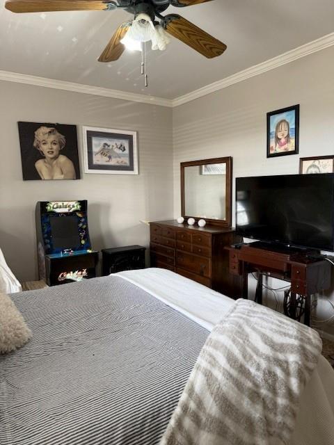 bedroom with ornamental molding and ceiling fan