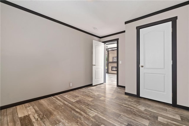 unfurnished bedroom with ornamental molding and wood-type flooring