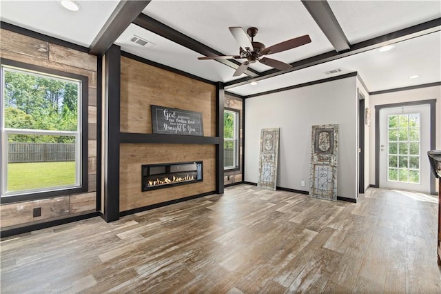 unfurnished living room with a large fireplace, beam ceiling, ceiling fan, and hardwood / wood-style floors