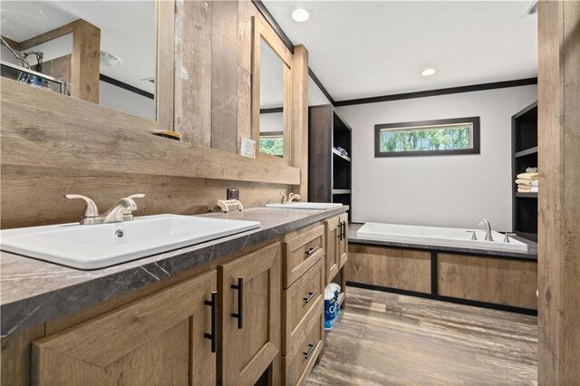 bathroom featuring hardwood / wood-style floors, a bathing tub, crown molding, and double sink vanity