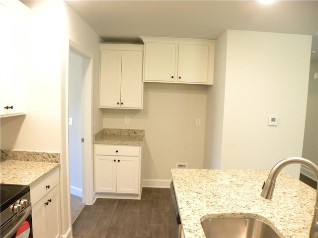 kitchen featuring light stone countertops, dark hardwood / wood-style flooring, sink, white cabinetry, and stainless steel electric range