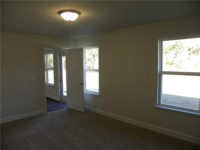 spare room featuring dark colored carpet