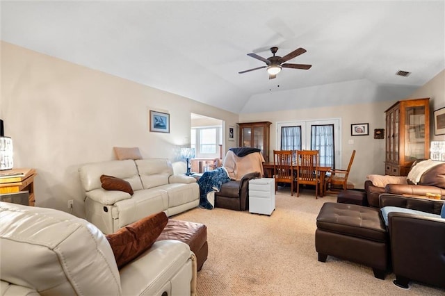 living room with ceiling fan, vaulted ceiling, and light carpet