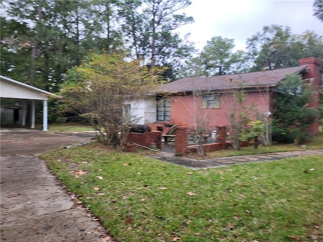 view of side of property featuring a carport and a lawn