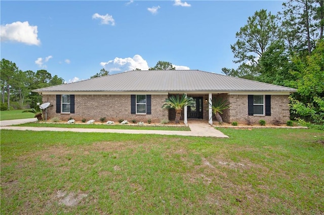 ranch-style home featuring a front yard, metal roof, and brick siding