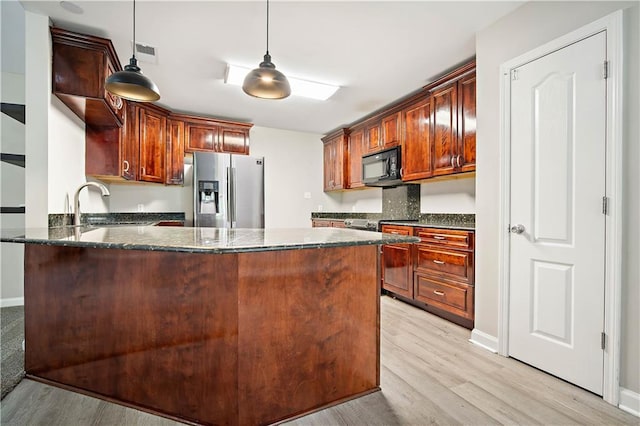 kitchen featuring stainless steel refrigerator with ice dispenser, black microwave, a peninsula, and light wood-style floors