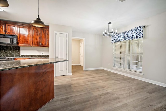 kitchen with black microwave, a chandelier, baseboards, and light wood-type flooring