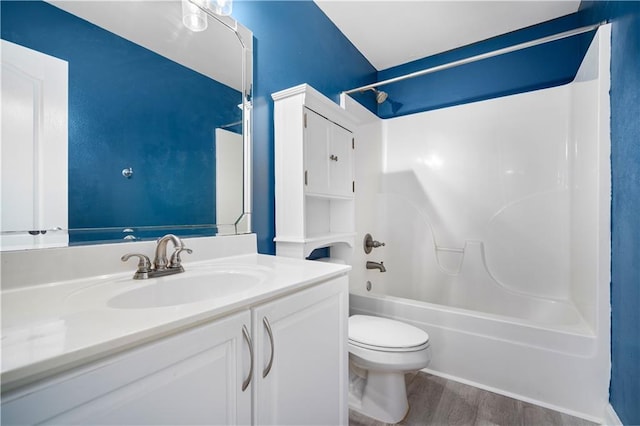 bathroom featuring bathing tub / shower combination, wood finished floors, vanity, and toilet