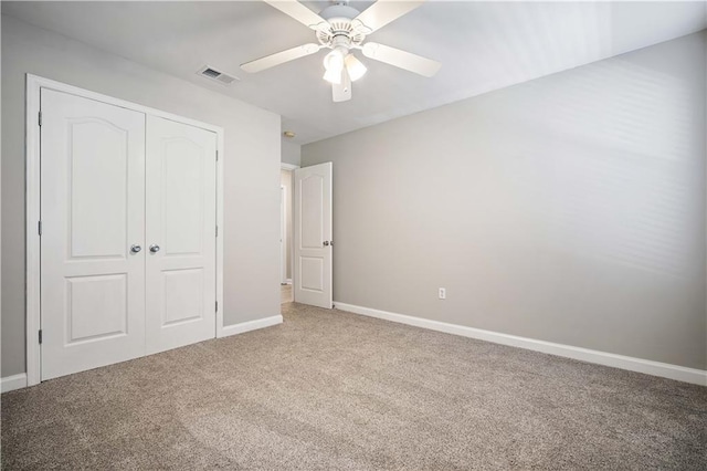 unfurnished bedroom featuring carpet flooring, a closet, baseboards, and ceiling fan