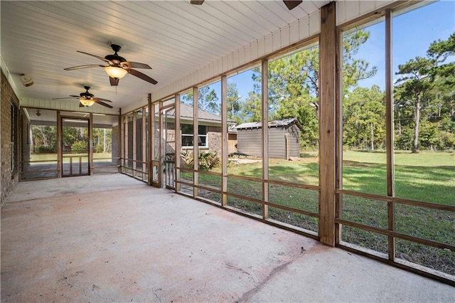 unfurnished sunroom with a ceiling fan and plenty of natural light