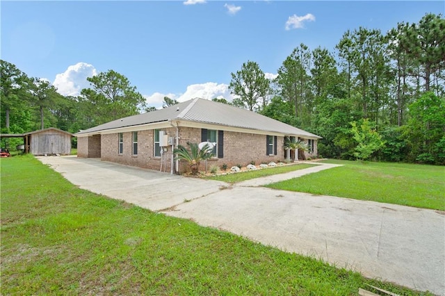view of front of property with a storage shed, an outdoor structure, concrete driveway, brick siding, and a front lawn