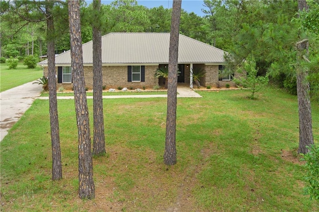 ranch-style house with driveway, a front lawn, metal roof, and brick siding