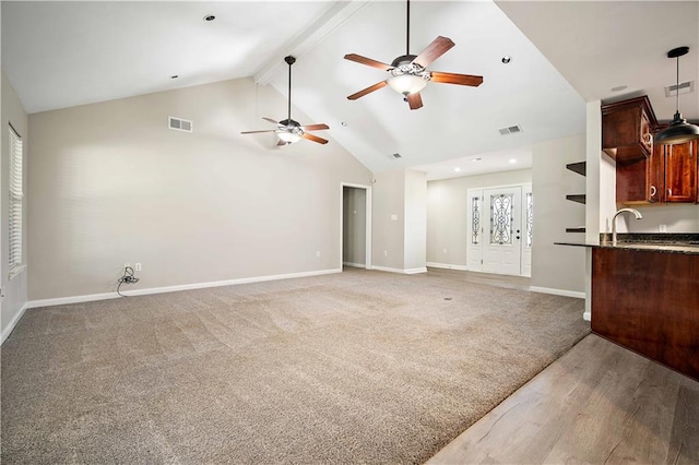 unfurnished living room with high vaulted ceiling, carpet flooring, ceiling fan, and beam ceiling