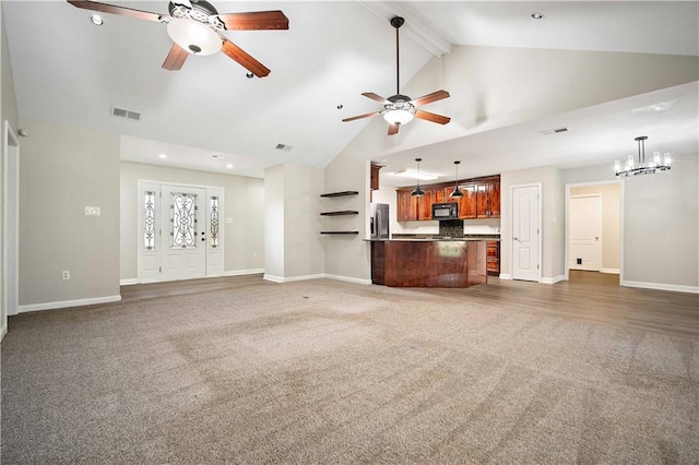 unfurnished living room with carpet flooring, a ceiling fan, high vaulted ceiling, a chandelier, and baseboards