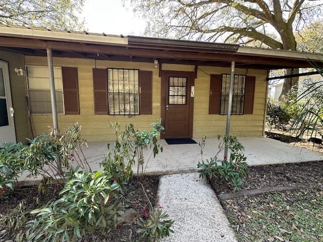 view of exterior entry with a porch