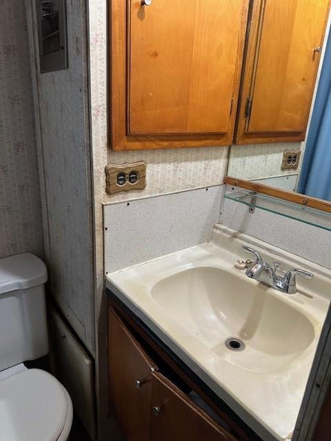 bathroom featuring toilet and vanity