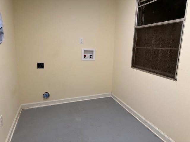 clothes washing area with hookup for a washing machine, baseboards, and laundry area