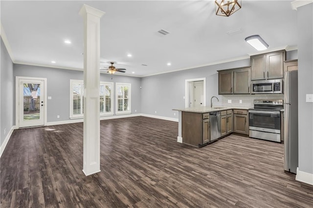 kitchen with sink, crown molding, appliances with stainless steel finishes, decorative columns, and kitchen peninsula