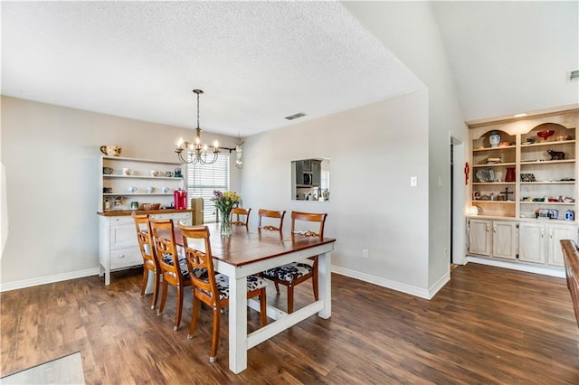 dining space featuring baseboards, visible vents, dark wood finished floors, a textured ceiling, and a chandelier