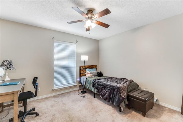 bedroom with a textured ceiling, carpet floors, a ceiling fan, and baseboards