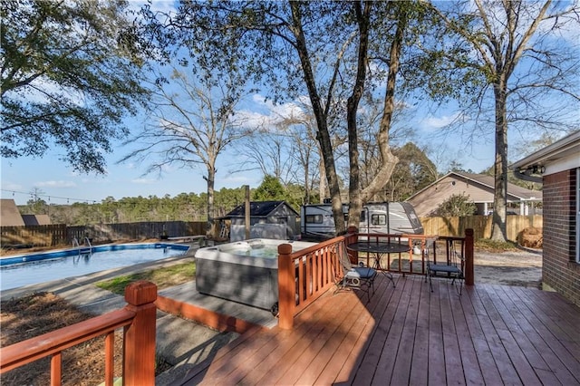 deck featuring a fenced in pool, a fenced backyard, and a jacuzzi