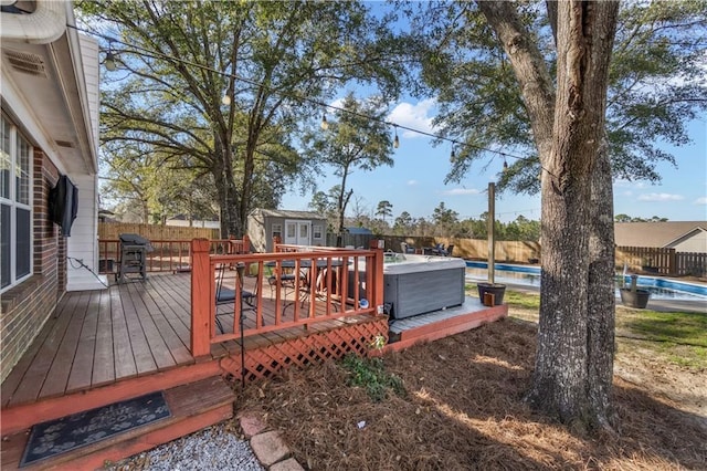 deck with a pool and a fenced backyard