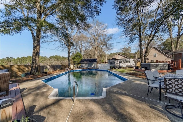 view of pool with a fenced backyard, a wooden deck, a fenced in pool, a patio area, and a hot tub