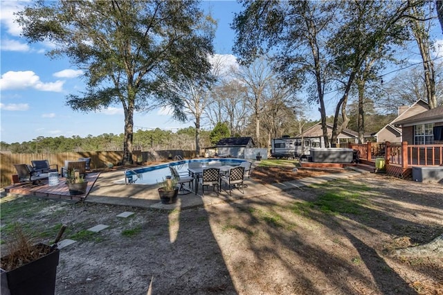 view of swimming pool featuring a jacuzzi, a fenced in pool, a deck, and a fenced backyard