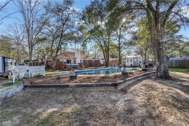 view of yard featuring a fenced in pool, fence, and an outdoor structure