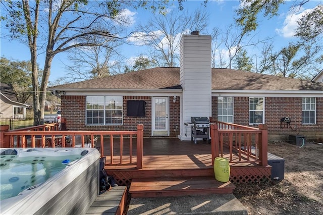 deck with fence, a hot tub, and area for grilling