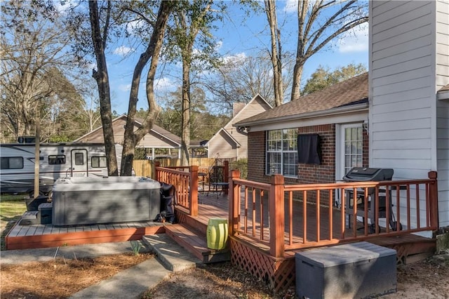 wooden terrace featuring grilling area, fence, and a hot tub